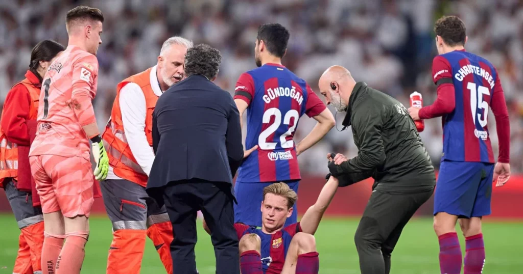 Frenkie de Jong of FC Barcelona reacts after injuring himself during the LaLiga EA Sports match between Real Madrid CF and FC Barcelona