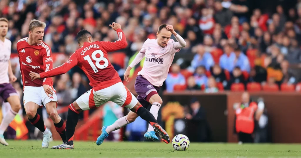 Casemiro of Manchester United tackling a Brentford player.