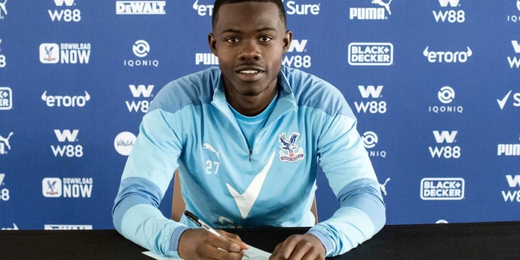 Mitchell putting pen to paper at Palace